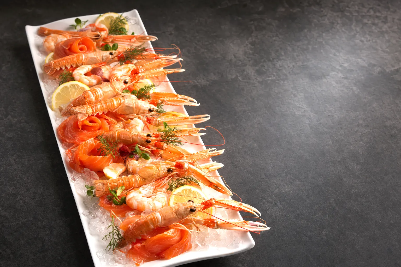 Koud traiteurschotel met zalm, langoustines en garnalen, klaar om af te halen.